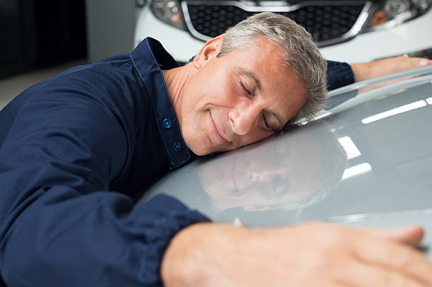 A man hugging his car
